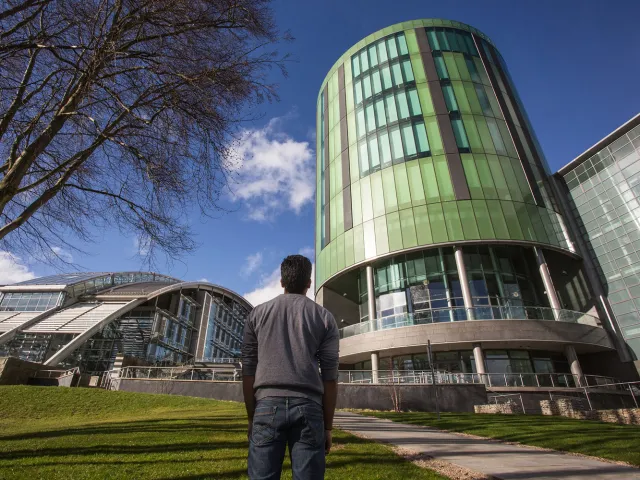 student looking up at Sir Ian Wood building