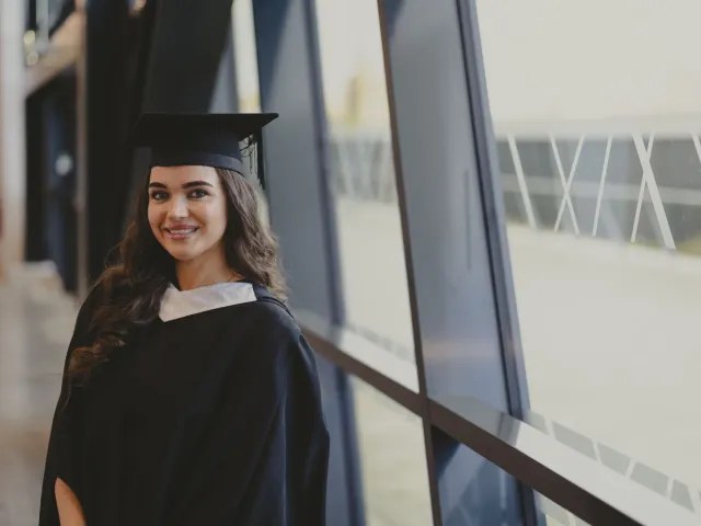 Kirsty Stewart smiling in graduation robes and hat