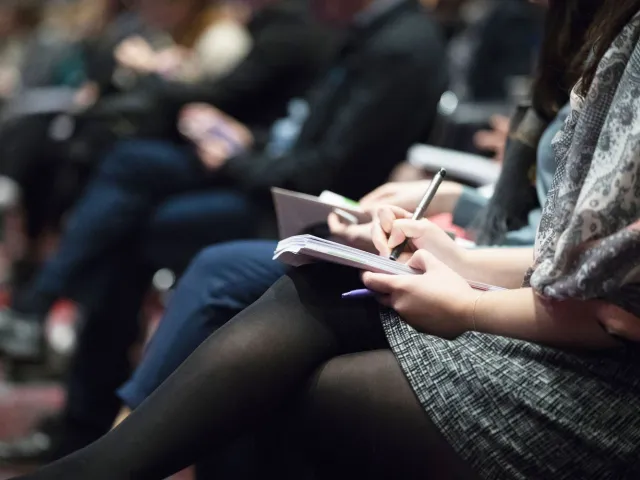 woman taking notes during a lecture