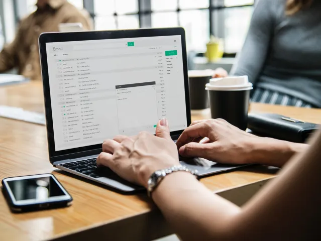 person writing an email on a laptop