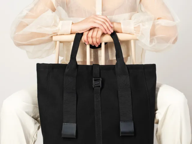 Person holding large black handbag