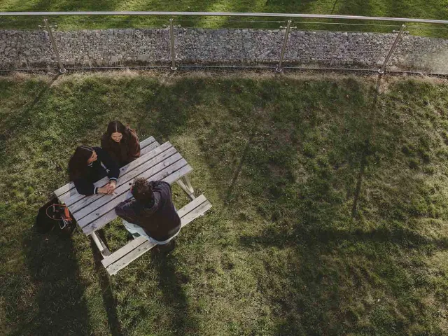 Students sitting at bench pictured from above