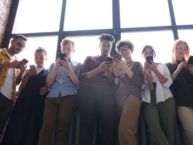 people standing next to window using their phones