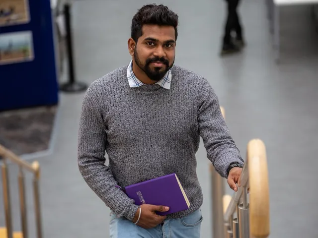 student walking up the stairs on campus