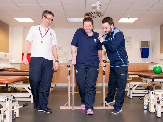 health professionals helping someone to walk