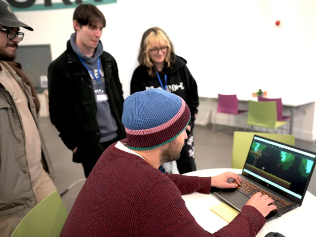 Students looking at a screen with a game playing