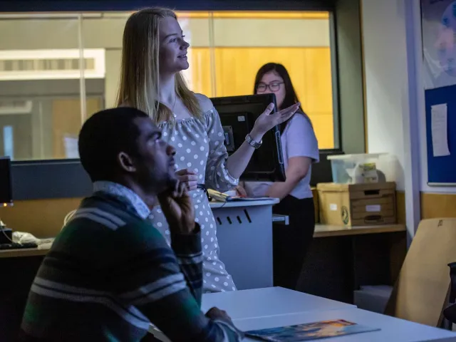 lecturer in the classroom explaining something to a student