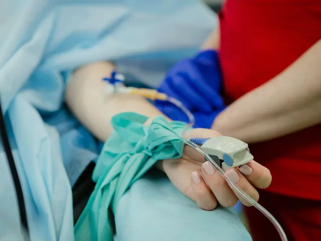 patient with an IV and pulse oximeter