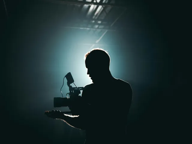 sillhouette of a man standing near a microphone