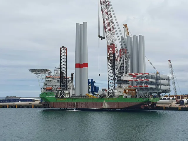 crane boat next to wind turbines