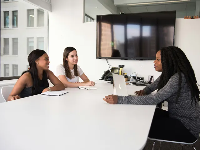 people chatting at a desk
