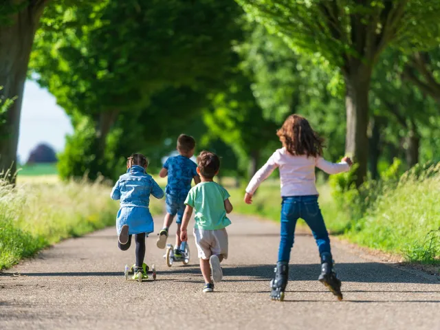 Children skating and running down a path