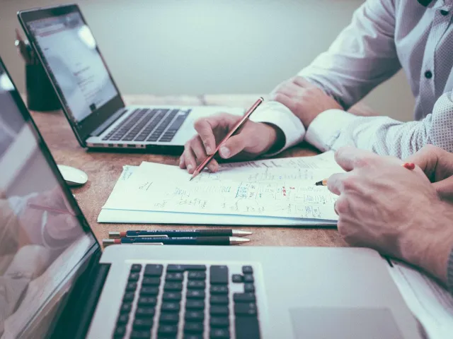 Person holding a pencil at a meeting