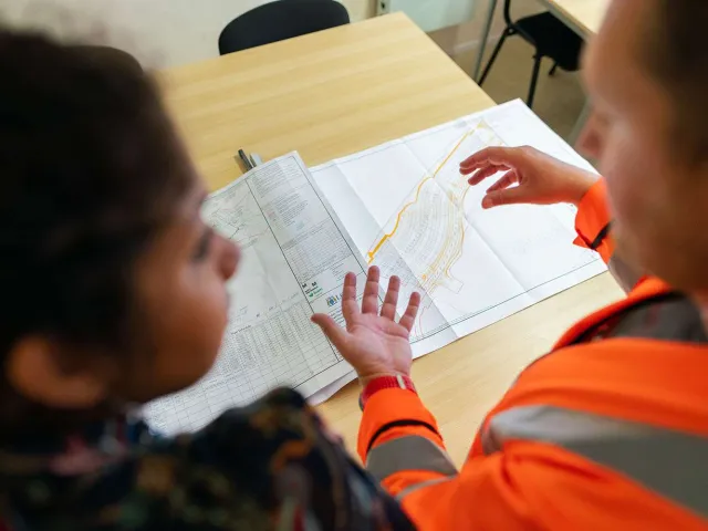 two people chatting next to a technical drawing