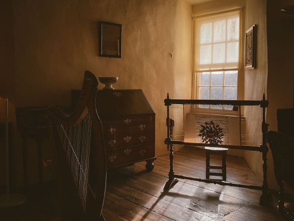 room with dresser, harp and various furnishings