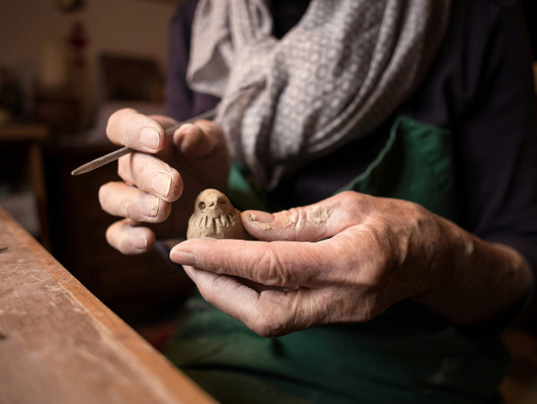 hands crafting clay bird figure