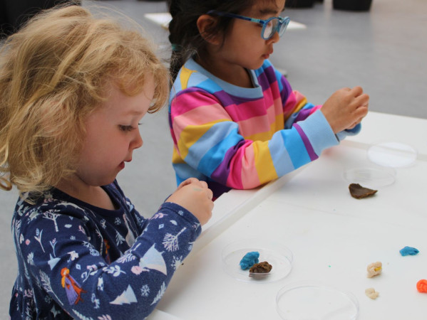 Two nursery children playing with science