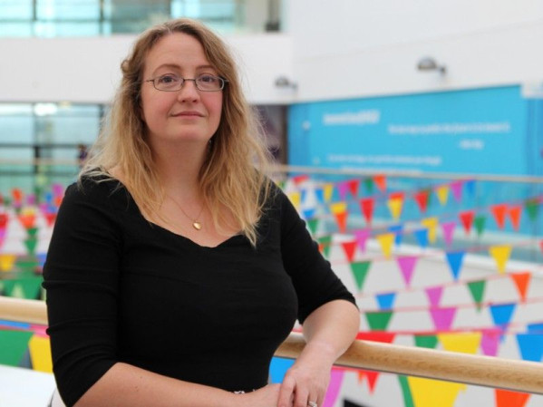 Dr Jo-Anne Tait posing in front of colourful flags at RGU Dr Jo-Anne Tait posing in front of colourful flags at RGU