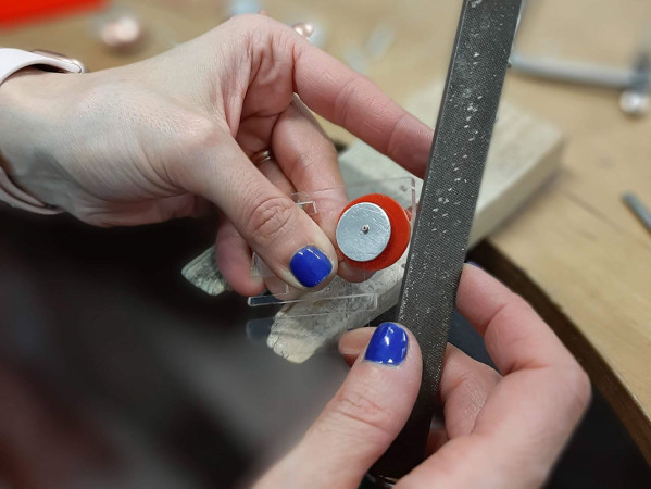 Person using a file on some jewellery