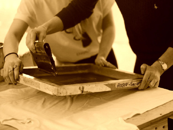 Sepia toned image of people screenprinting Sepia toned image of people screenprinting