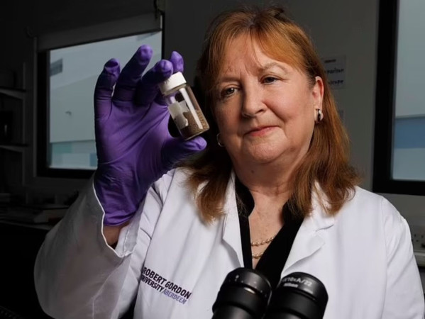 Professor Dame Lorna Dawson looking at a sample in a lab