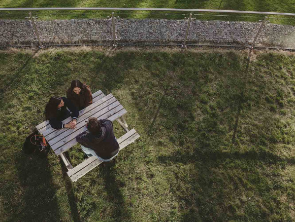 Students sitting at bench pictured from above