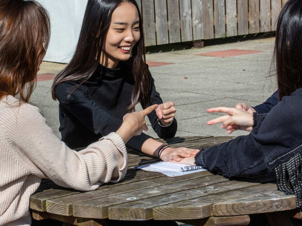 students laughing on a picnic bench students laughing on a picnic bench