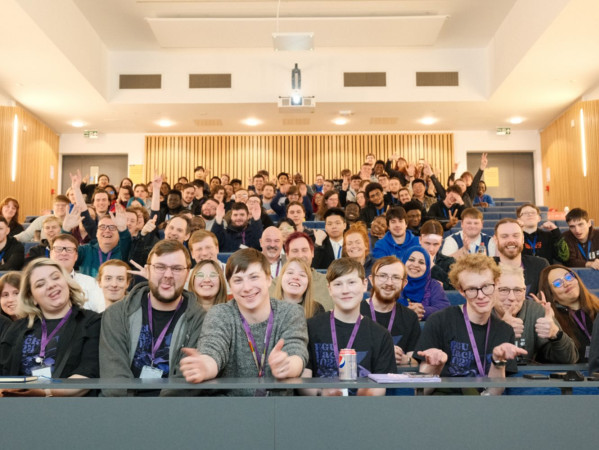 Staff and students posing in a lecture theatre