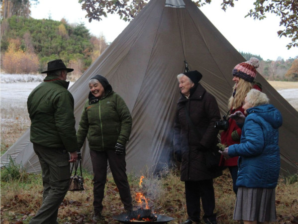 A group of elders standing next to a tent