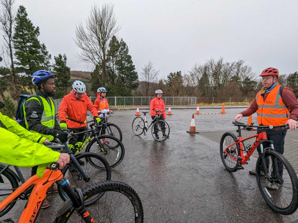 cyclists in high vis jackets listening to an instructor