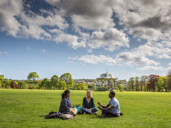 three people sitting in grass in Duthie Park Aberdeen three people sitting in grass in Duthie Park Aberdeen