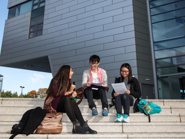 students sitting on the steps near Sir Ian Wood Building