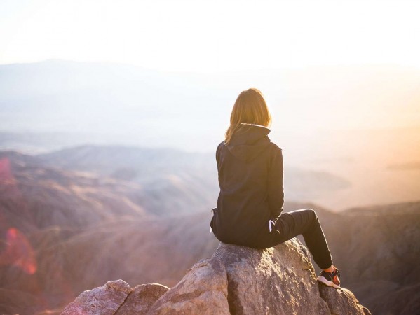 girl on a mountain looking at the sun rise